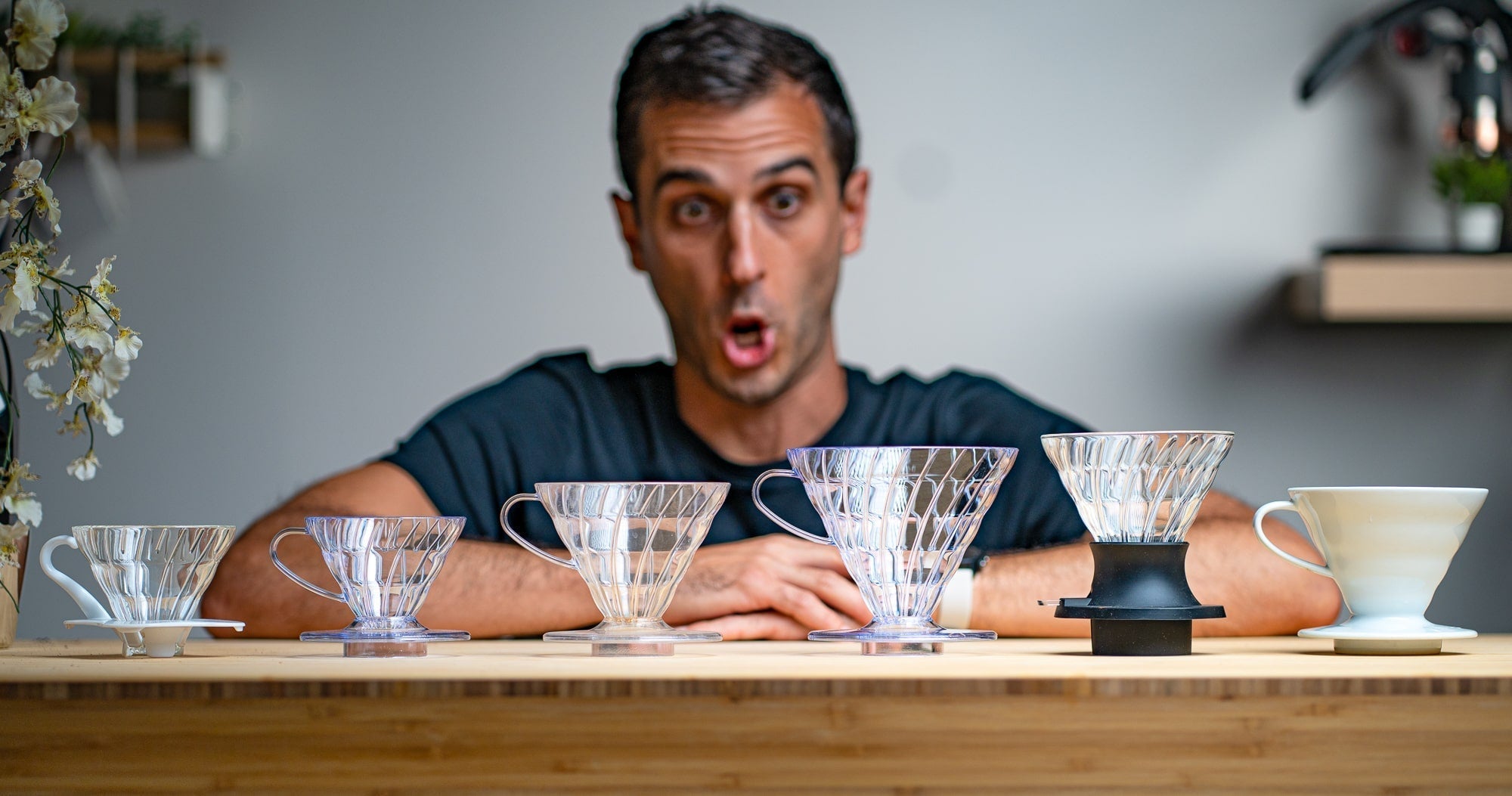 Rob in front of several V60 coffee brewers - glass, plastic, ceramic, and the Hario Switch