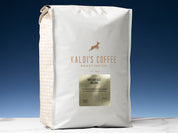 A 5lb bag of Brekfast Blend sits on marble countertop in front of an uplit blue wall