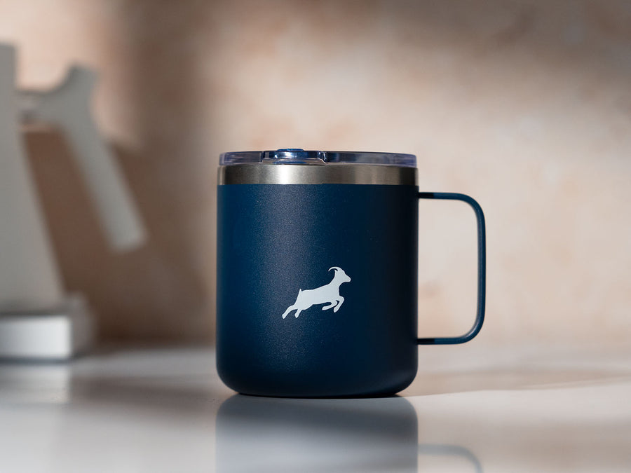 A blue mug with Kaldi's goat logo sits on a counter