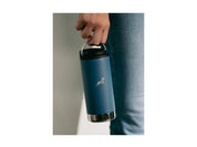 A blue Klean Canteen hangs low beside a leg, dangled from it's metal ring.