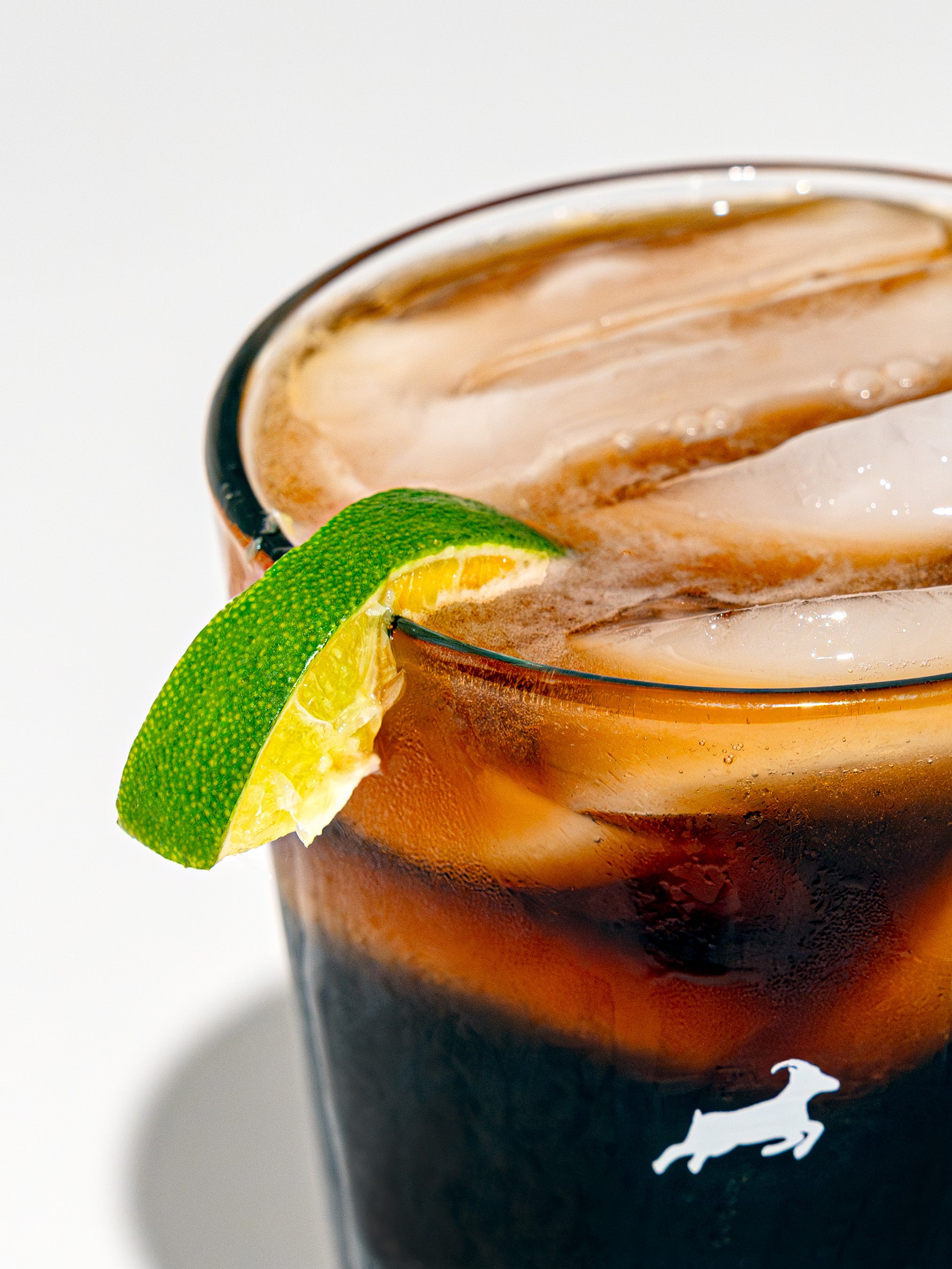 A wedge of lime sits on the rim of a Key Lime Cold Brew Seltzer