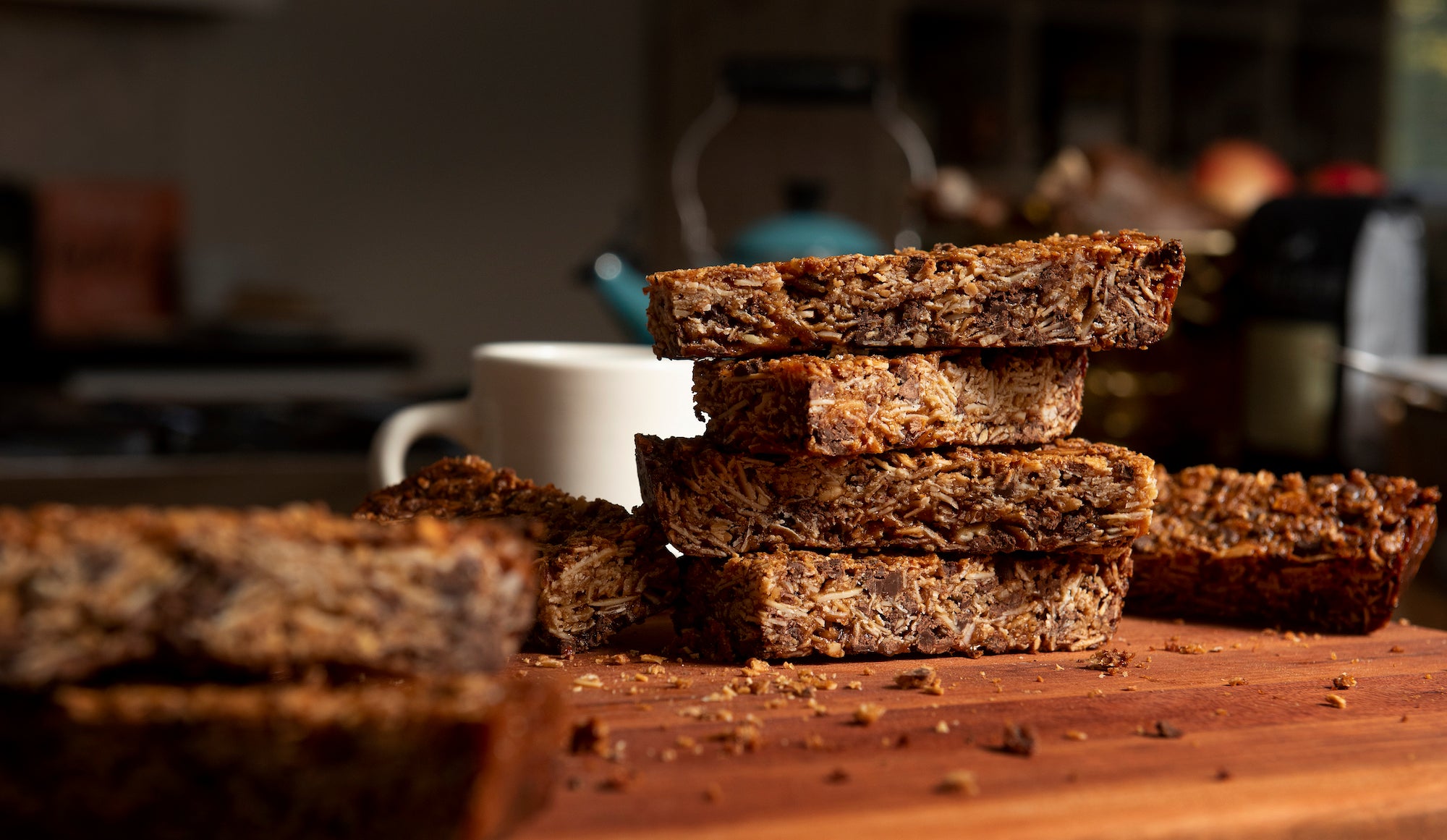 Granola bars stacked next to a mug of coffee