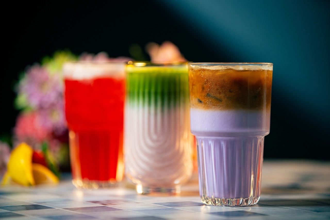 3 colorful drinks in glasses with floral background