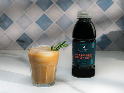 A glass of Brown Sugar Rosemary next to a 16oz bottle of Kaldi's Coffee Cold Brew Concentrate