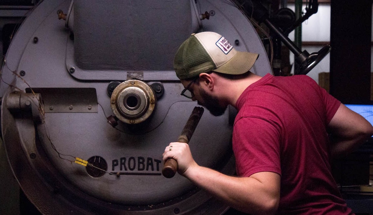 A coffee roaster roasting coffee on a coffee roaster