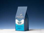12 oz bag of Dancing Goats Blend on a white marble counter, with a blue background