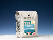 A 2lb bag of Highlander Grogg sits on marble countertop in front of an uplit blue wall