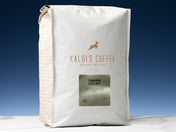 A 5lb bag of Cinnamon Hazelnut sits on a marble countertop in front of a blue wall