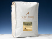 A 5lb bag of Birds and Bees sits on marble countertop in front of an uplit blue wall