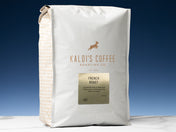 A 5lb bag of French Roast sits on marble countertop in front of an uplit blue wall