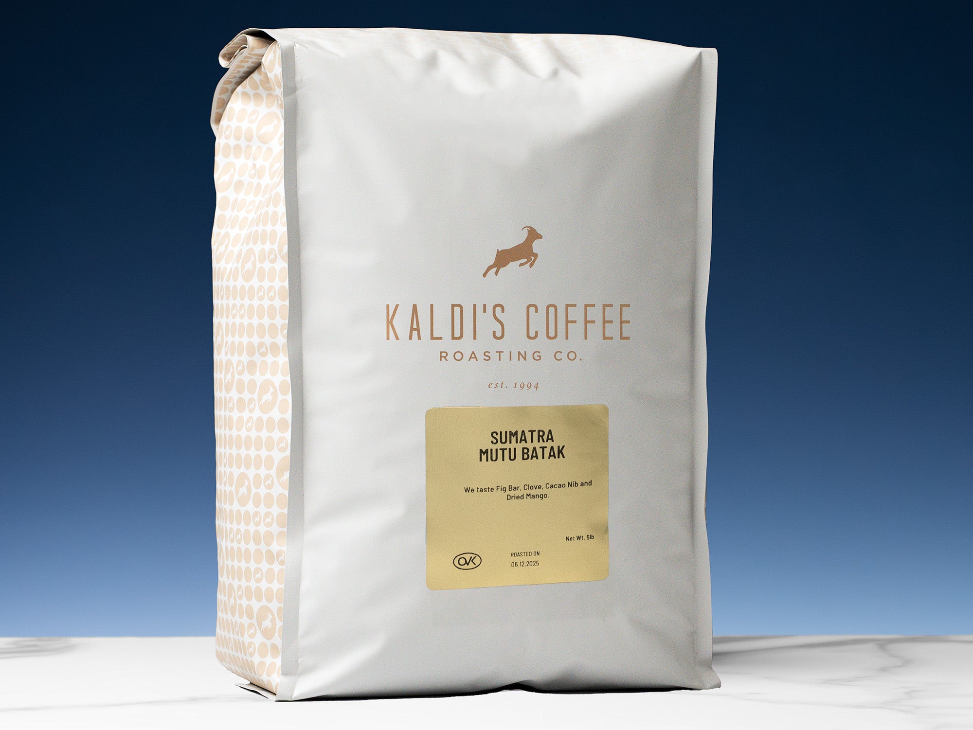 A 5lb bag of Sumatra Mutu Batak sits on a marble countertop in front of a blue wall