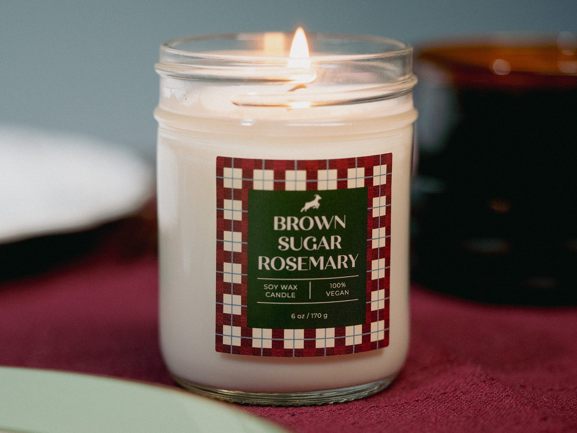 Candle with a 'Brown Sugar Rosemary' label on a checkered cloth