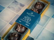 Box of chocolates with a blue label on a tiled floor