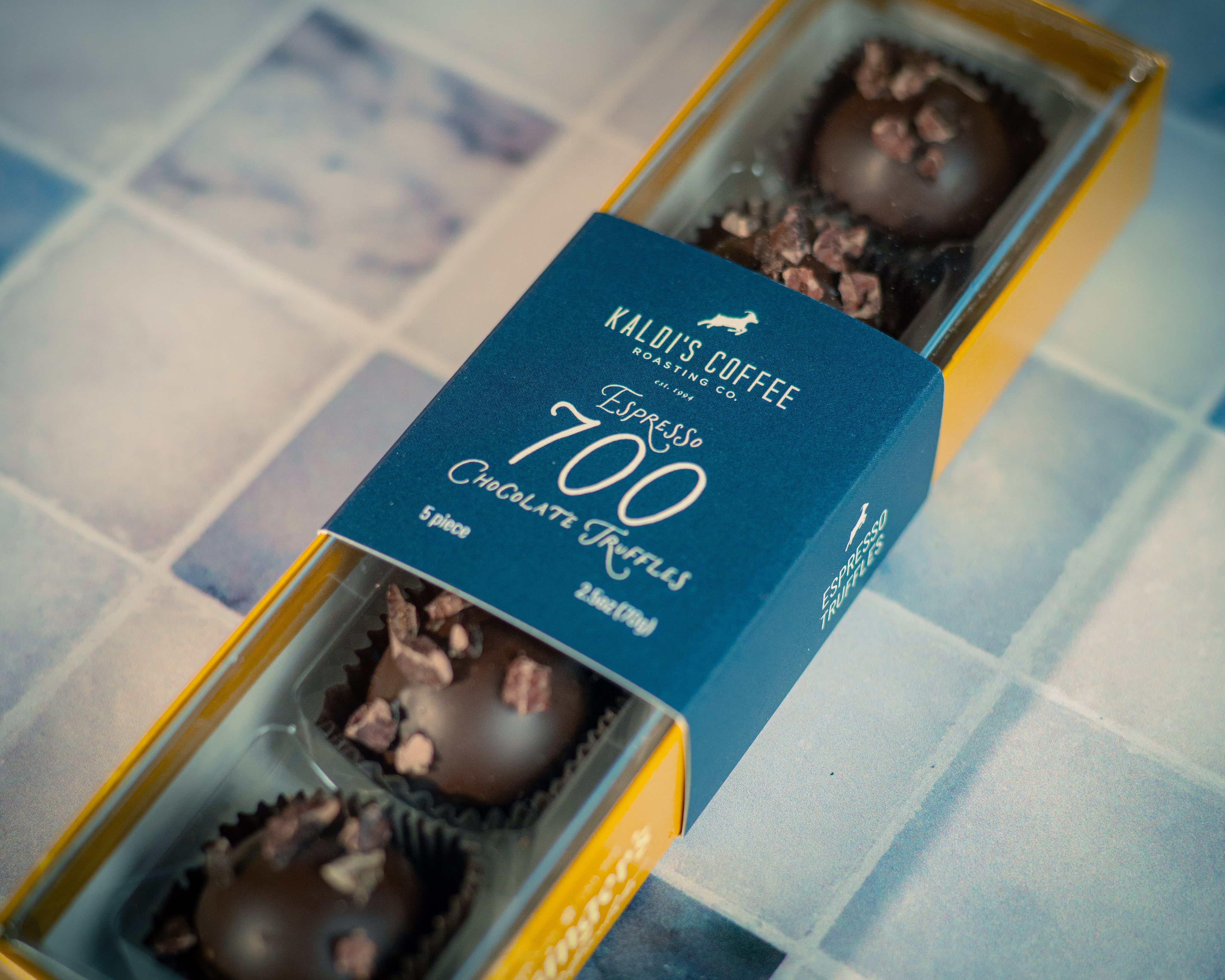 Box of chocolates with a blue label on a tiled floor