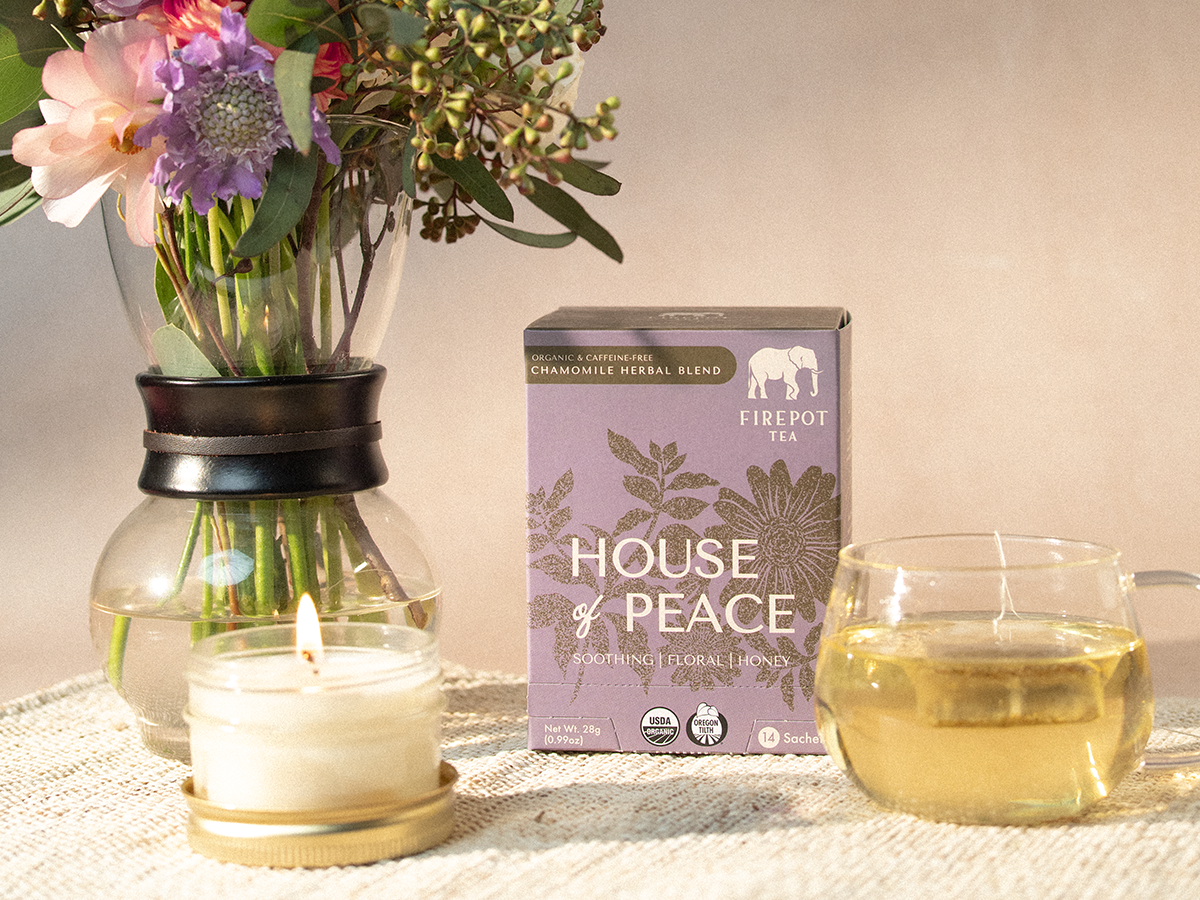 house of peace box and glass mug of light yellow tea