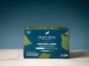 A box of Kaldi's Coffee Roasting Co. Natural High ground coffee, featuring a dark blue and green design with yellow-green palm leaf illustrations.