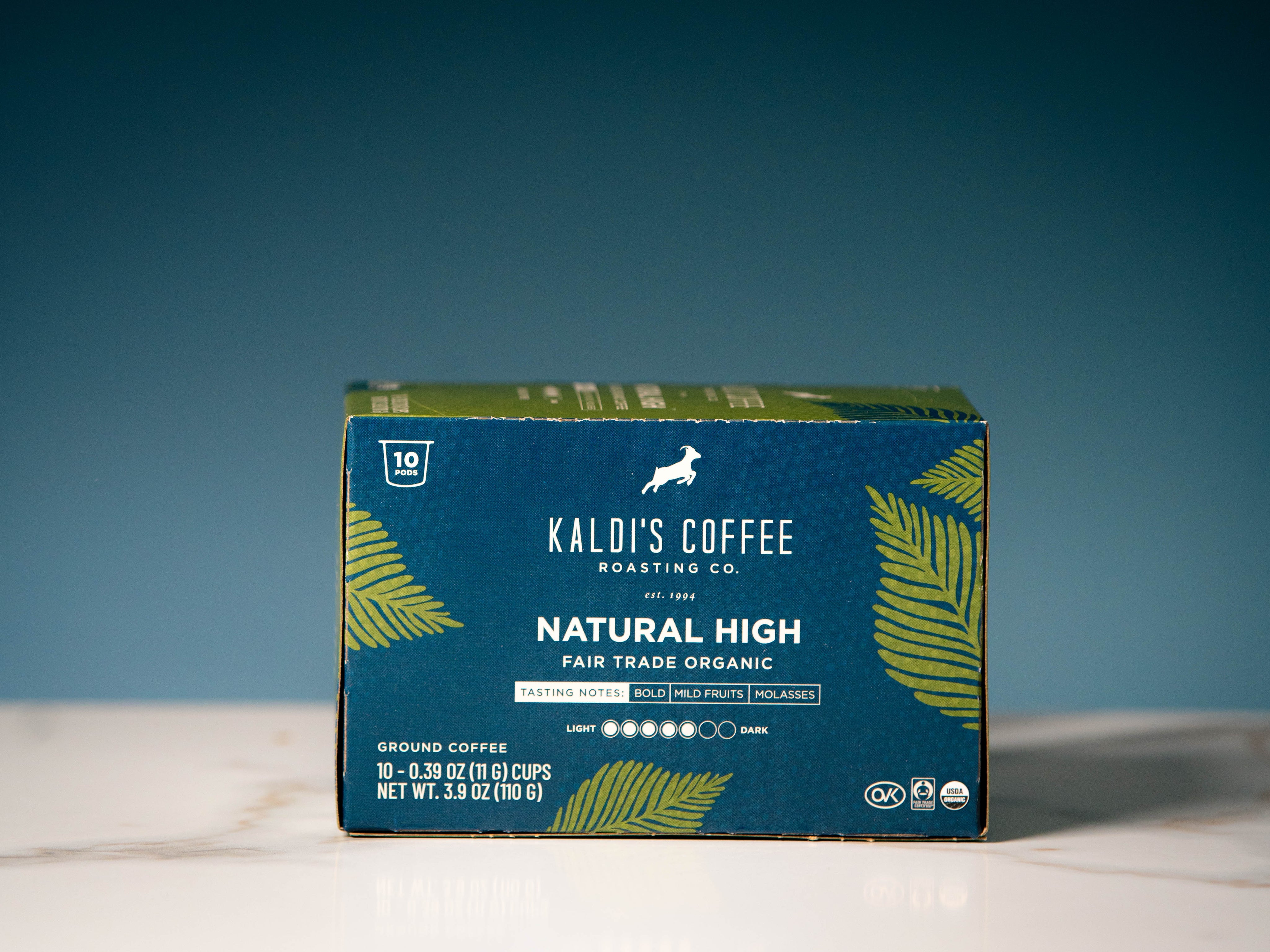 A box of Kaldi's Coffee Roasting Co. Natural High ground coffee, featuring a dark blue and green design with yellow-green palm leaf illustrations.
