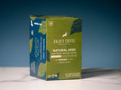A box of Kaldi's Coffee Natural High Fair Trade Organic Coffee. The packaging is olive green with dark green palm leaf illustrations and a blue side panel.