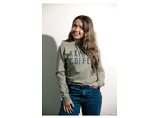 Woman wearing a green hoodie with text, standing against a plain background