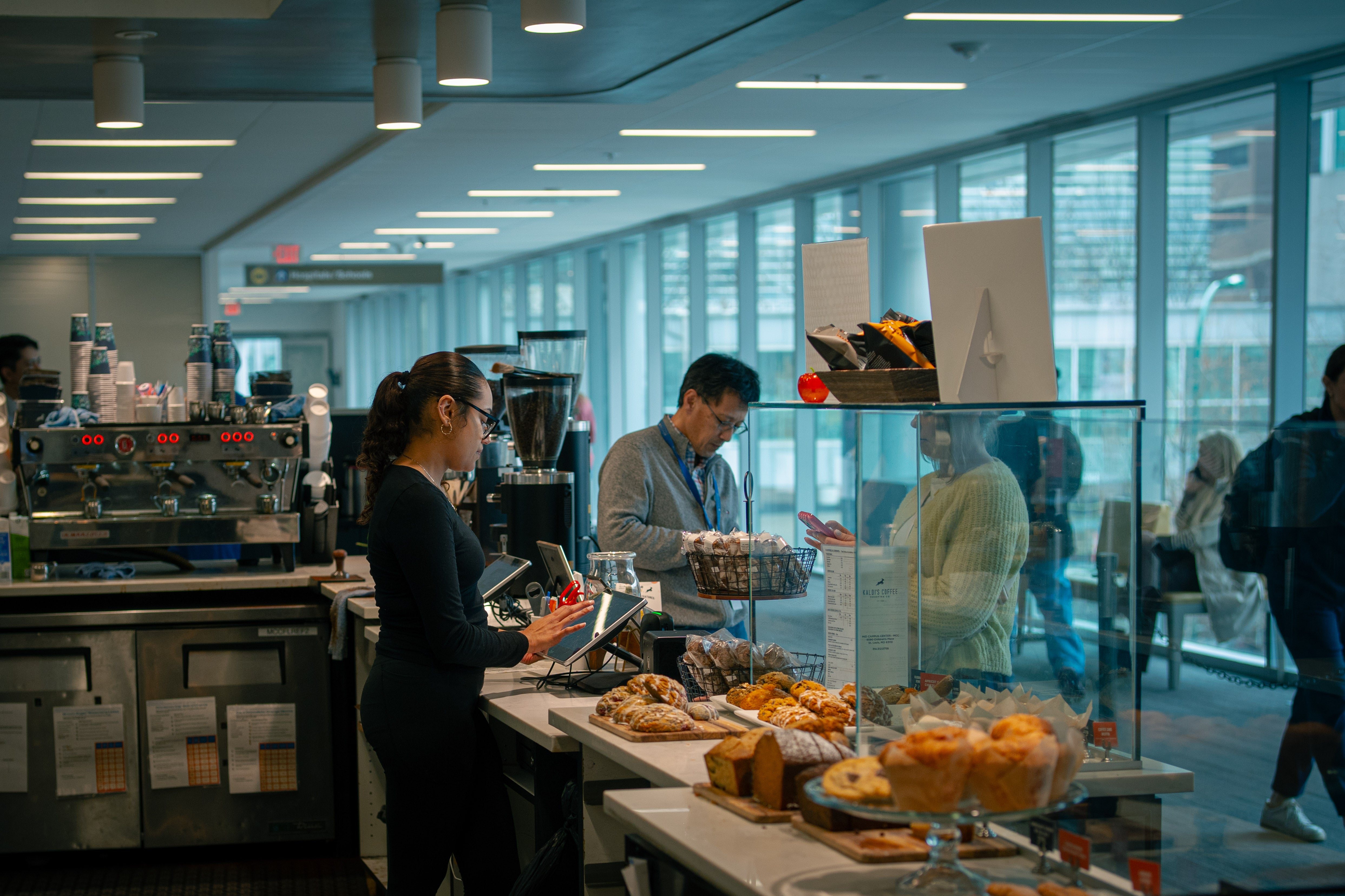People working in a modern kitchen with large windows