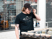Person tasting coffee in a roastery setting