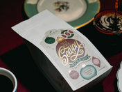 Mocha Java coffee package with decorative design on a table with a cup of coffee.