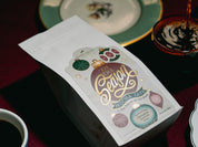 Mocha Java coffee package with decorative design on a table with a cup of coffee.