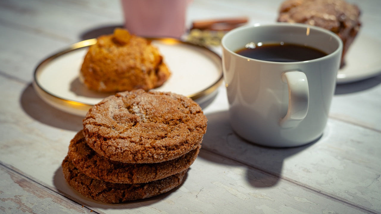 Stack of cookies with a cup of coffee on a wooden surface
