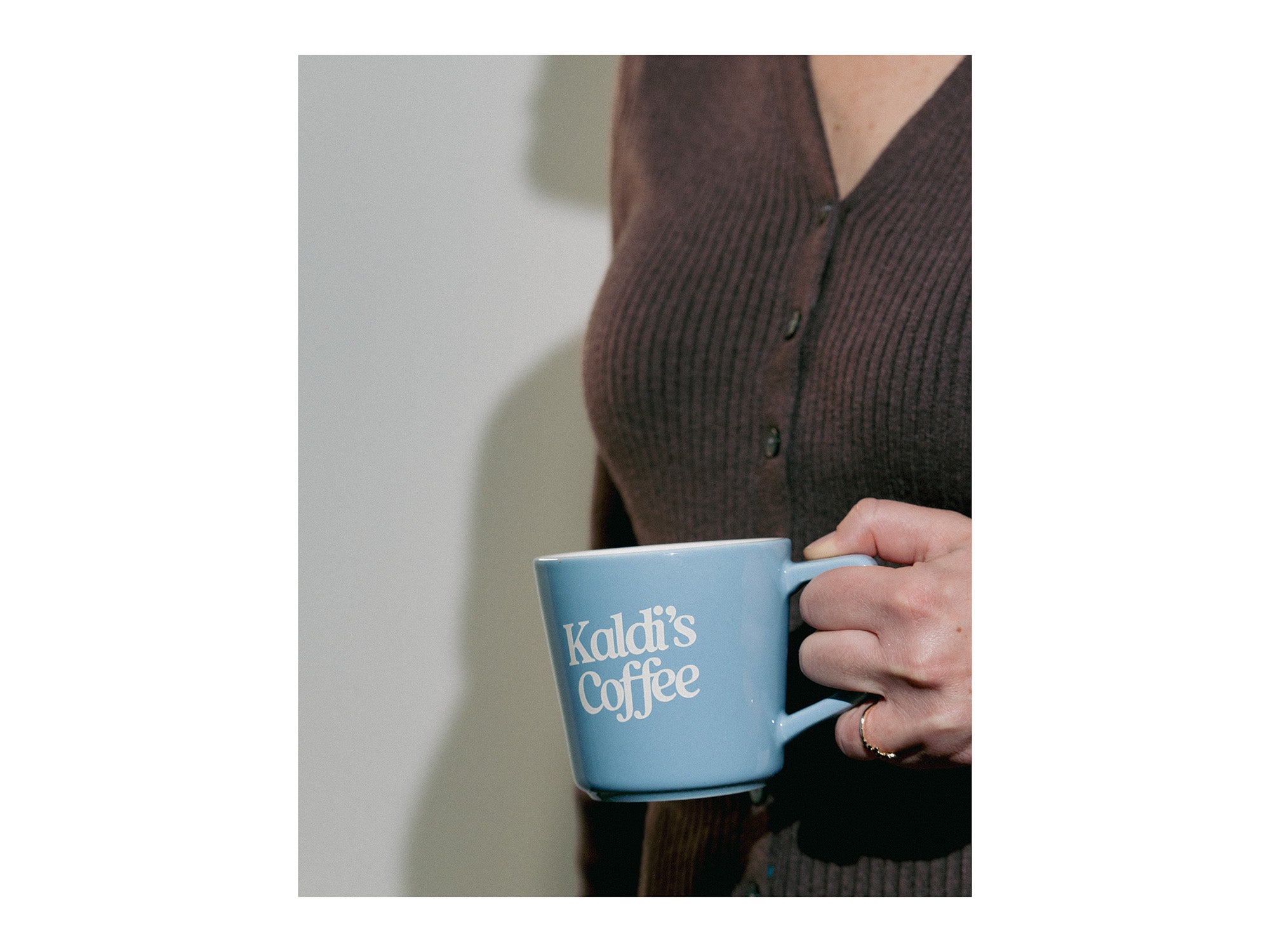 Image of hand holding kaldi's coffee blue mug