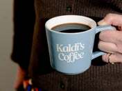 Image of someone holding Kaldi's Coffee blue angle drip mug