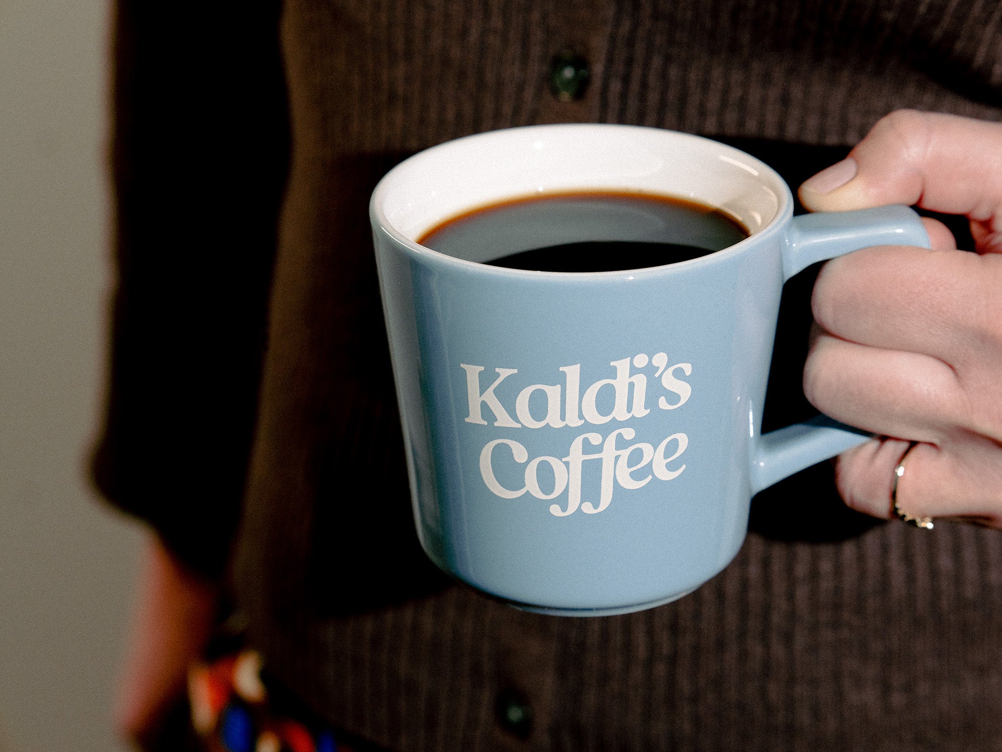 Image of someone holding Kaldi's Coffee blue angle drip mug