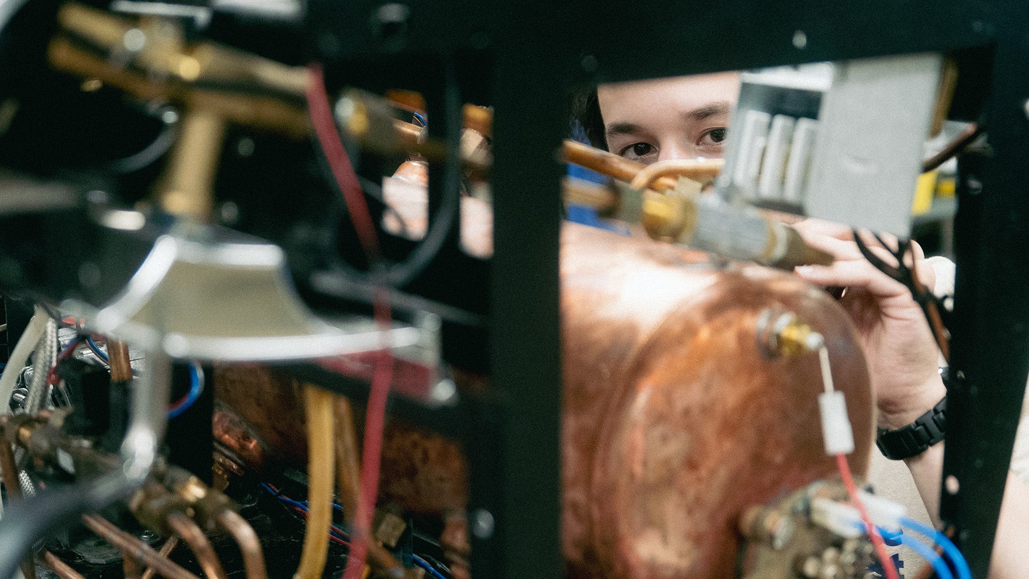 Person working on electronic equipment with close-up of hands and components