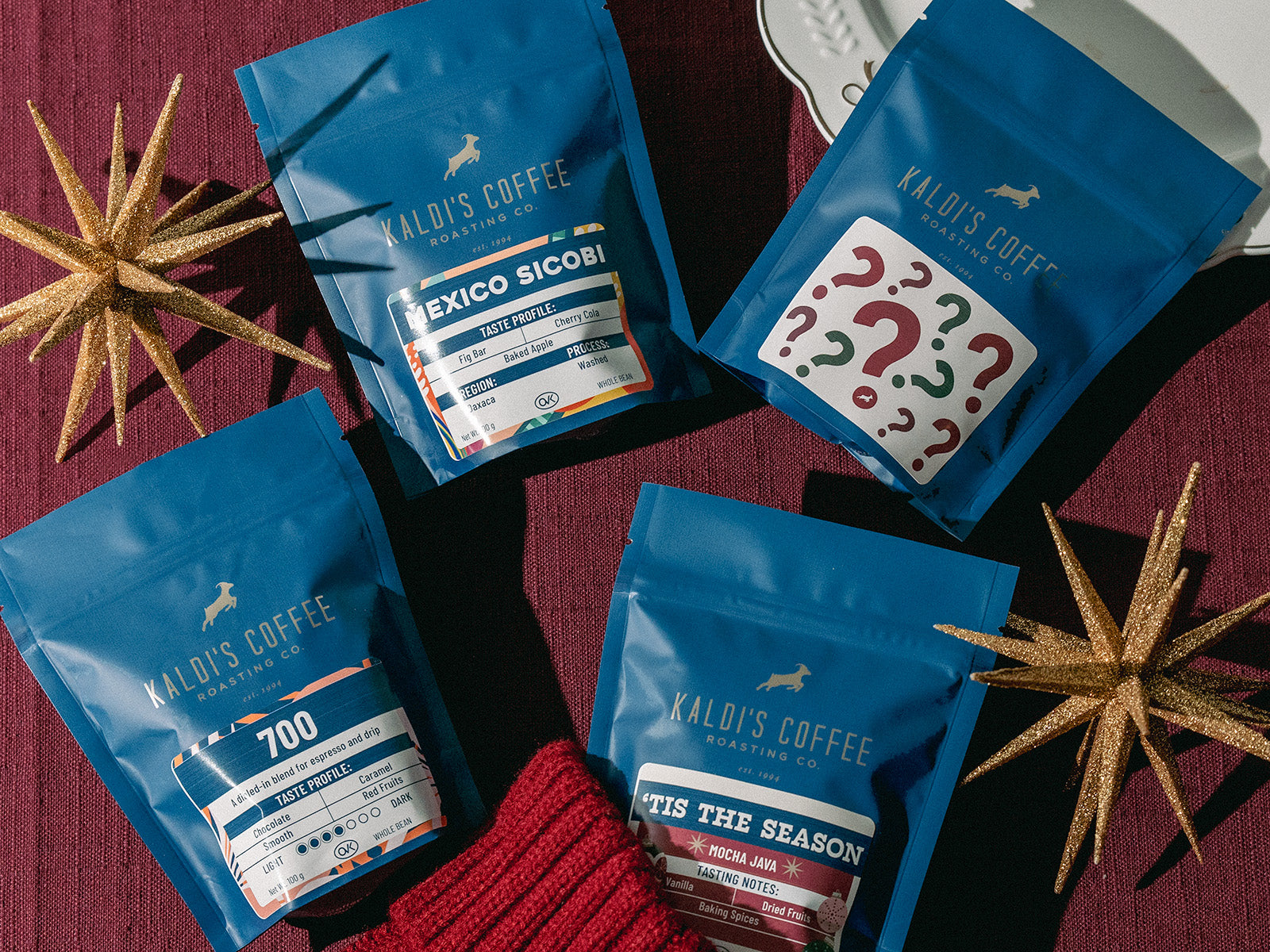 Kaldi's Coffee packages on a red surface with decorative elements